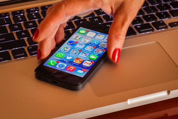 How to Easily transfer photos from your iPhone to a computer 2 A woman about transferring photos from her iPhone to a laptop Effortlessly Transfer Photos from iPhone to Your Computer.